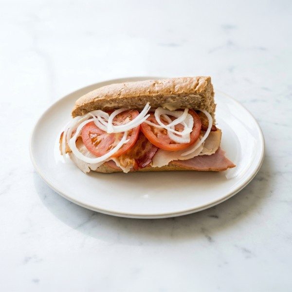Sub sandwich piled with turkey, tomato, and onion